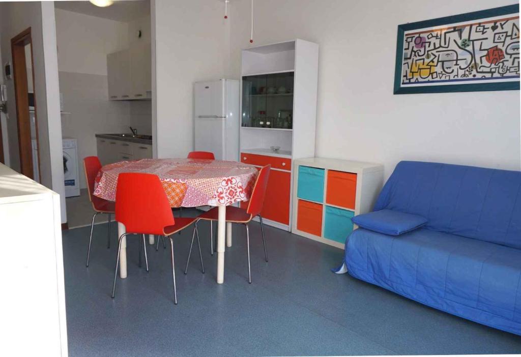 eine Küche mit Tisch und Stühlen und einer Couch in der Unterkunft Studio in Porto Santa Margherita 40176 in Porto Santa Margherita