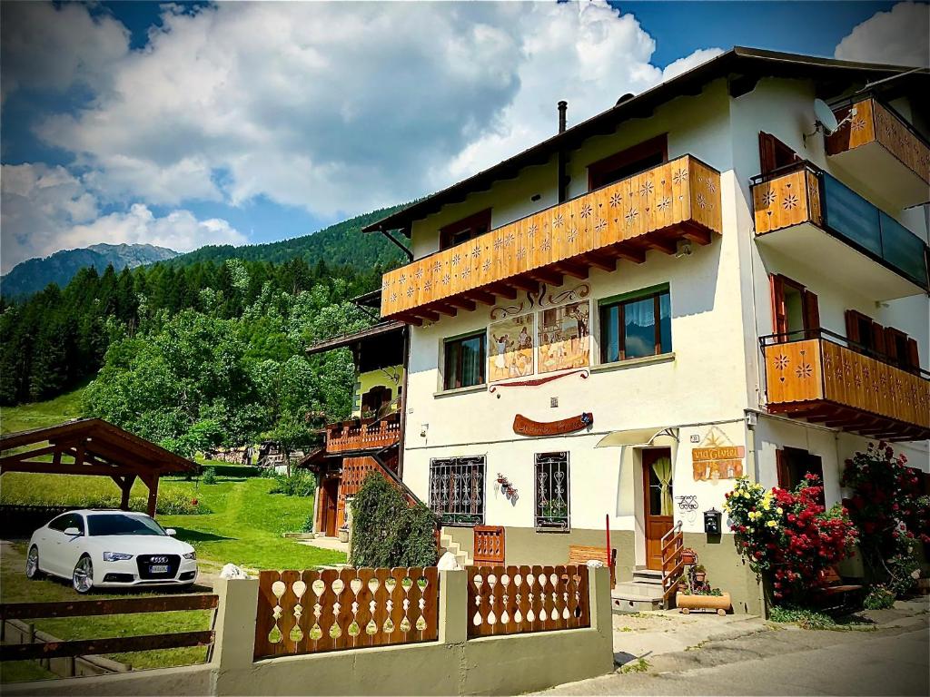 a white car parked in front of a house at Residence Dolomiti in Forni di Sopra