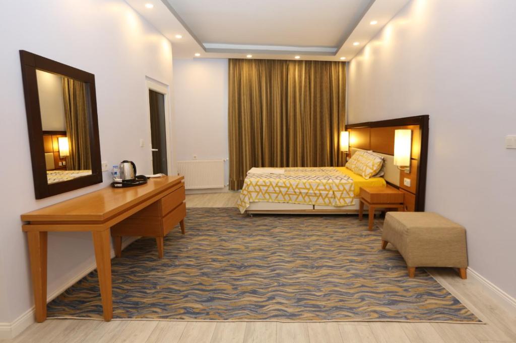 a hotel room with a bed and a desk at Kommageneiz hotel in Adıyaman