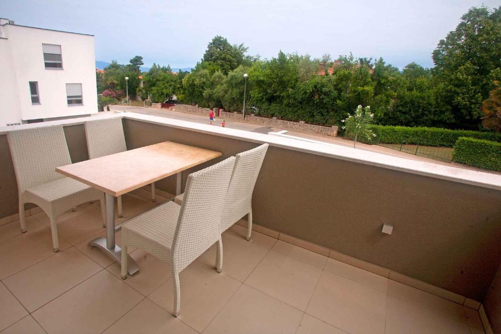 a table and chairs on a balcony with a view at Apartments in Njivice/Insel Krk 13314 in Njivice