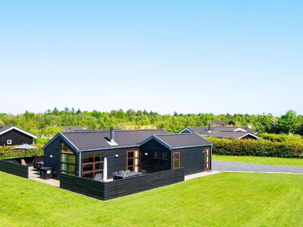 a black house on top of a green field at Four-Bedroom Holiday home in Hemmet 6 in Hemmet