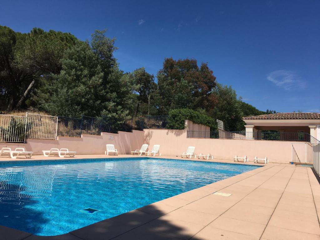 - une piscine avec des chaises blanches dans l'établissement Sainte-Maxime - 3 bedroom apartment, air conditioned, outdoor terrace, swimming pool, à Sainte-Maxime