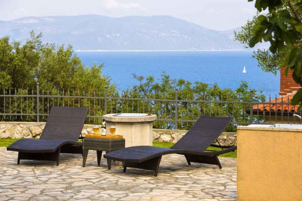 two chairs and a table with a view of the ocean at Apartment in Ravni - Istrien 8872 in Ravni