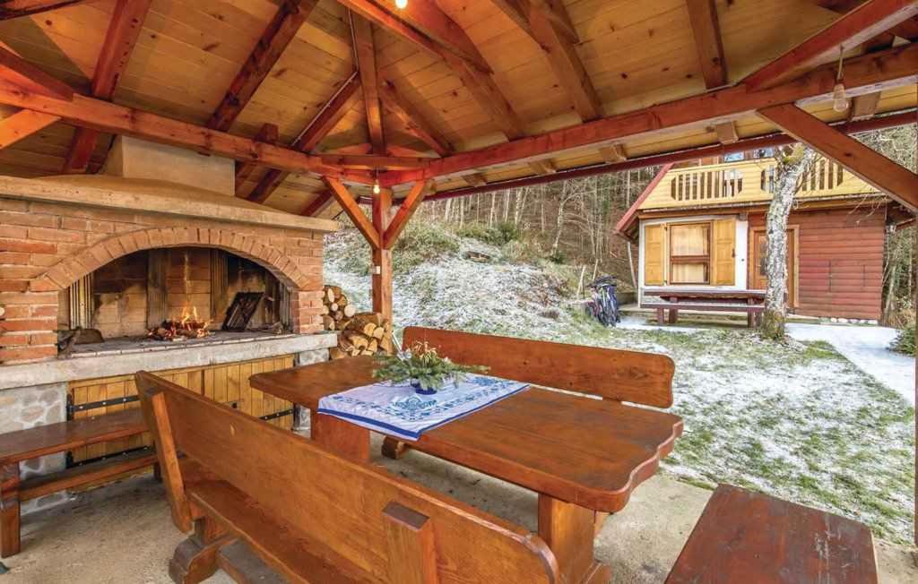 an outdoor patio with a table and a fireplace at Holiday home in Golik - Gorski Kotar 14249 in Zagolik