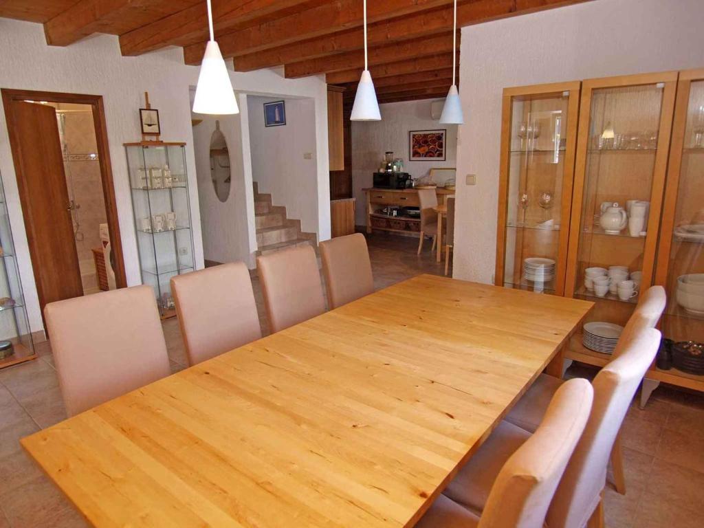 ein Esszimmer mit einem Holztisch und Stühlen in der Unterkunft Holiday home in Veli Losinj 36387 in Veli Lošinj