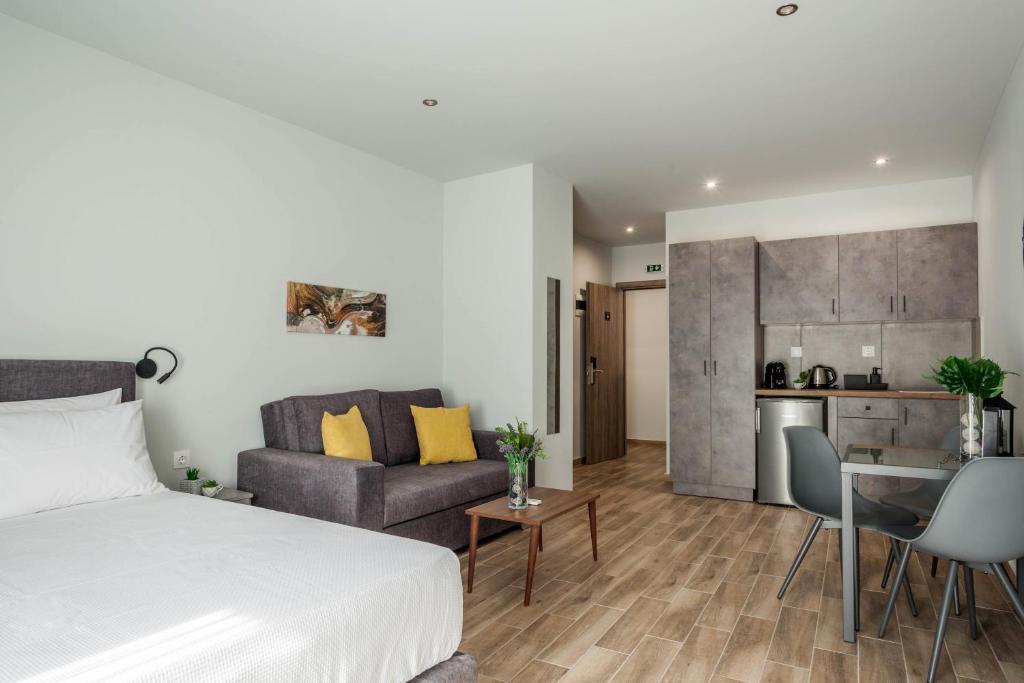 una camera da letto e un soggiorno con letto e cucina di Raise Heraklion Boutique Apartments a Heraklion