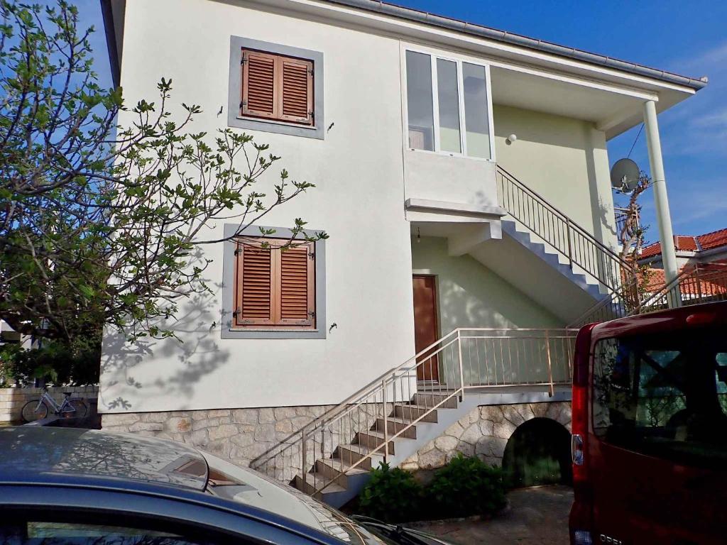 a white house with stairs in front of it at Apartments Seline/Paklenica Riviera 36550 in Seline