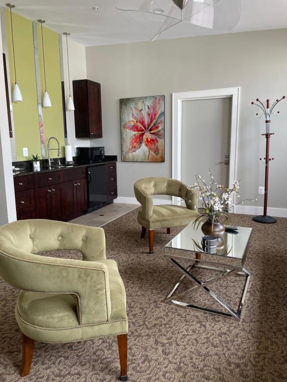 a living room with two chairs and a table at Culpeper Center Suites in Culpeper