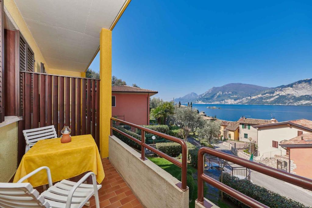 a balcony with a table and chairs and a view of the water at Apartments in Malcesine/Gardasee 22016 in Assenza di Brenzone