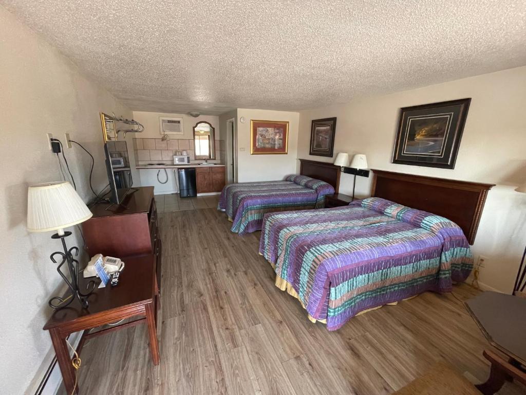 a hotel room with two beds and a kitchen at Round-Up Motel in Cheyenne