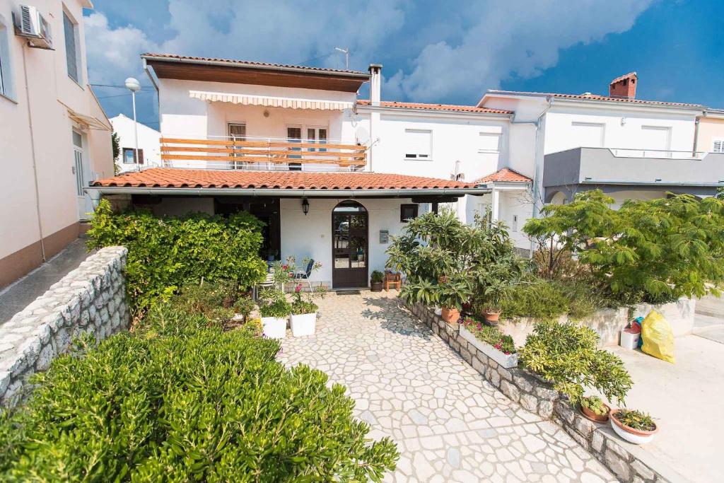 une maison dotée d'une cour avec des plantes devant elle dans l'établissement Apartments in Crikvenica 5669, à Crikvenica