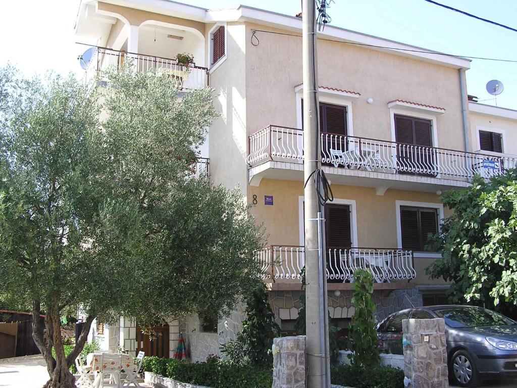 ein Gebäude mit Balkonen und einem davor geparkt in der Unterkunft Apartment in Silo/Insel Krk 13517 in Šilo