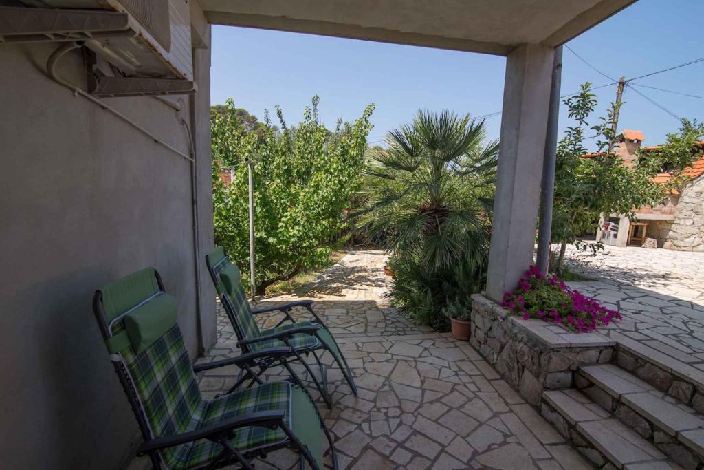 two green chairs sitting on a patio at Apartments in Veli Losinj 14928 in Veli Lošinj