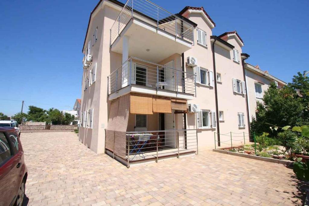a large house with a parking lot in front of it at Apartments in Silo/Insel Krk 13566 in Šilo