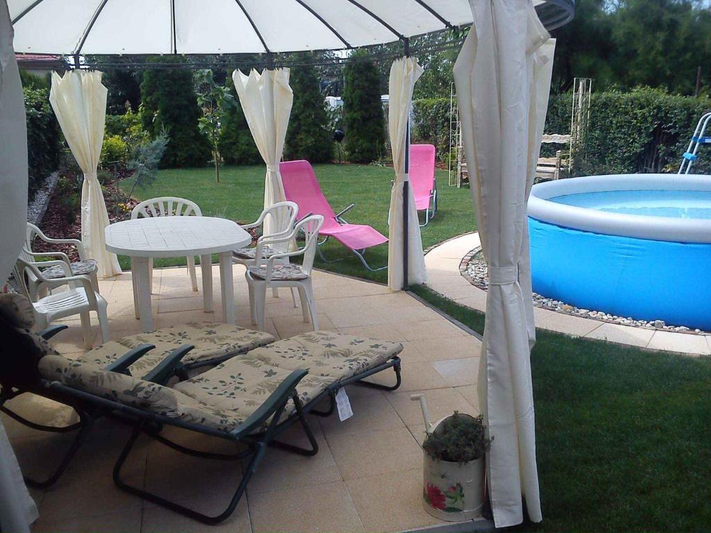 バラトンボグラールにあるTwo-Bedroom Holiday home with Pool in Balatonboglar/Balaton 18176のパティオ(テーブル、椅子付)、プールが備わります。