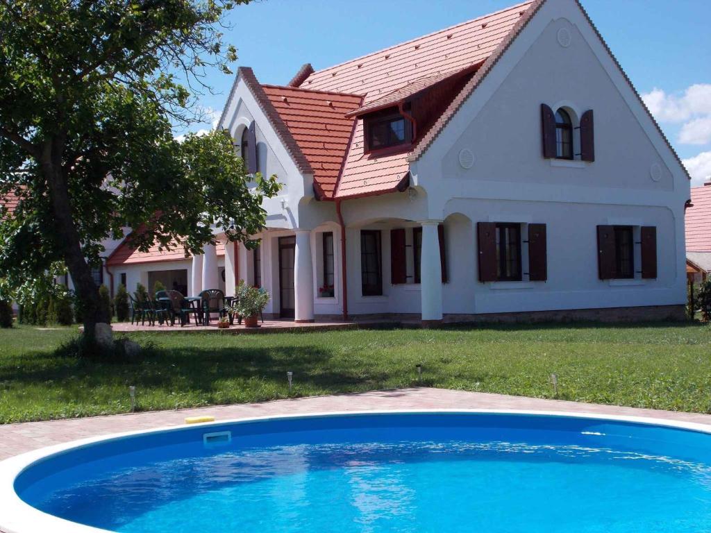 uma casa com uma piscina azul em frente em Holiday home Nagyvazsony/Balaton 20231 em Nagyvázsony