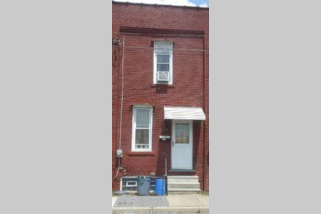 a brick house with a blue door and a window at Nice and cozy home for a business or family stay. in Johnstown