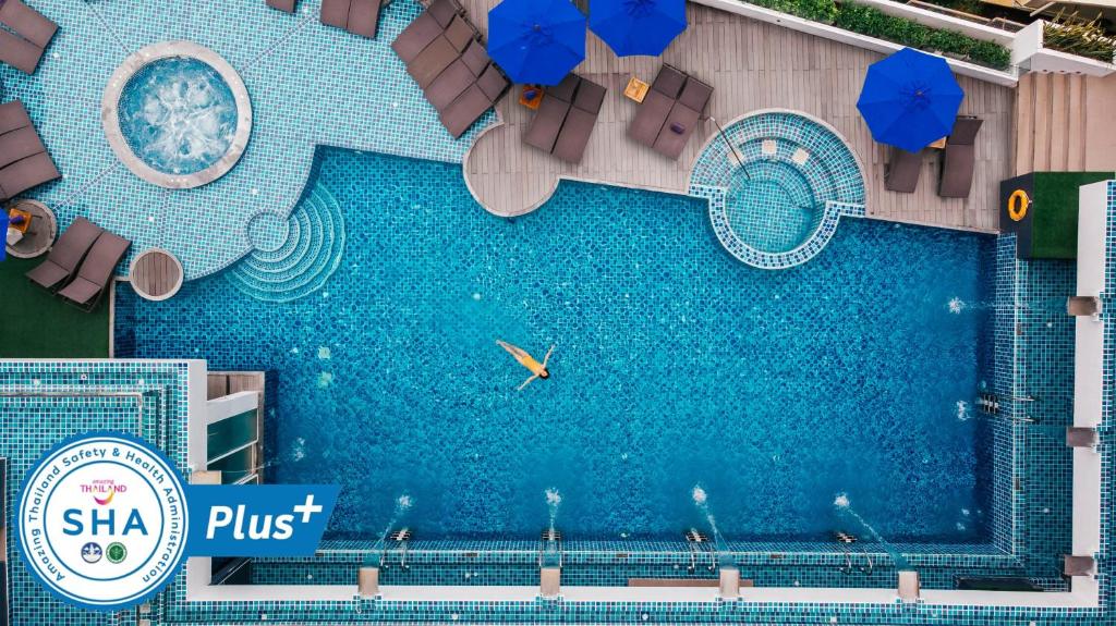 an overhead view of a swimming pool with umbrellas at The Yama Hotel Phuket - SHA Extra Plus in Kata Beach