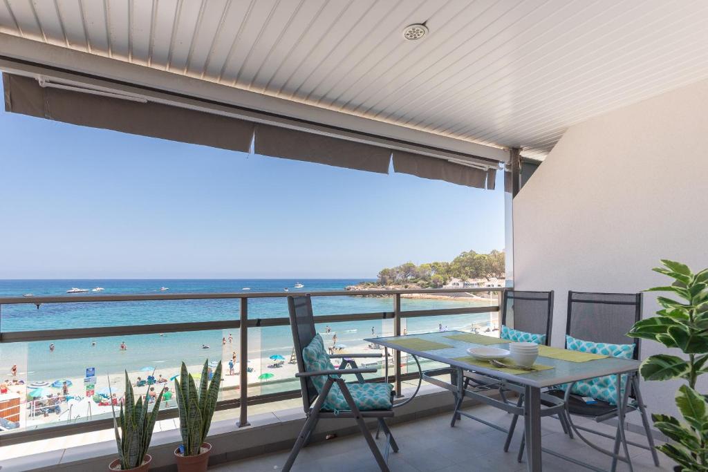 a balcony with a table and chairs and a view of the beach at Apartamento Frentemar 2 - Costa CarpeDiem in Calpe