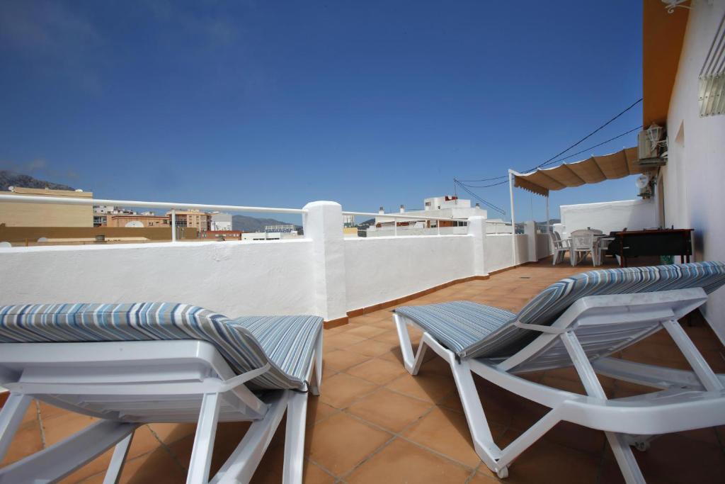 2 chaises et une table sur le toit dans l'établissement Pondarosa Penthouse 56 - Costa CarpeDiem, à Calp