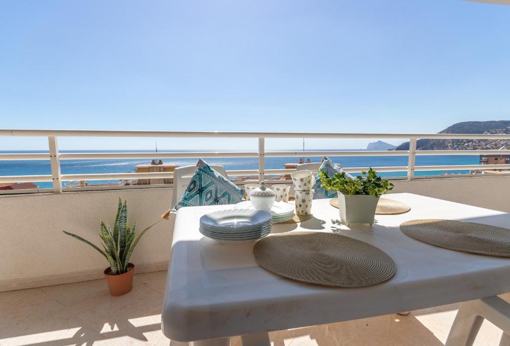 a table on a balcony with a view of the ocean at Apartamento Apolo XIV - Costa CarpeDiem in Calpe