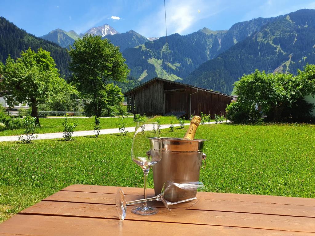 a bucket with a bottle of wine and a glass at LANDHAUS DORNAU Apartments in Mayrhofen