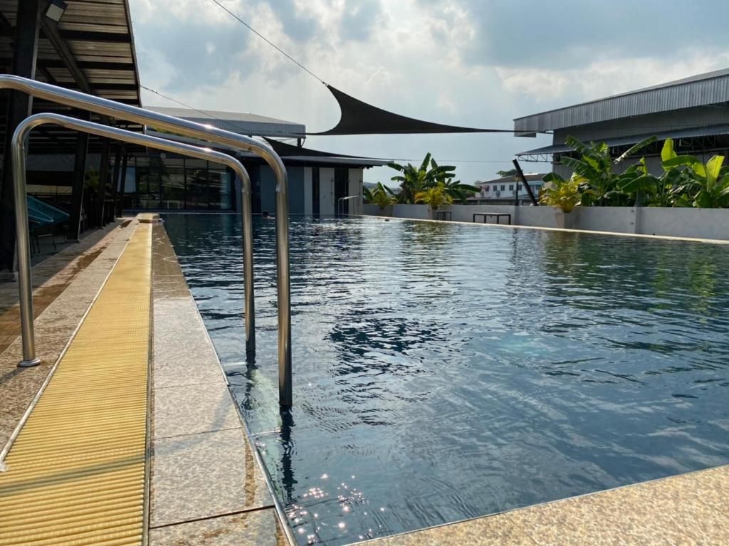 einem Pool an der Seite eines Gebäudes in der Unterkunft โรงแรมเกียรตินคร (Kiatnakhon Hotel) in Nakhon Si Thammarat