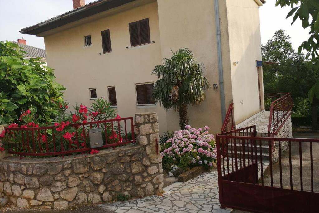 une maison avec un mur en pierre et des fleurs devant elle dans l'établissement Spacious 2-room apartment with beautiful sea view, à Crikvenica