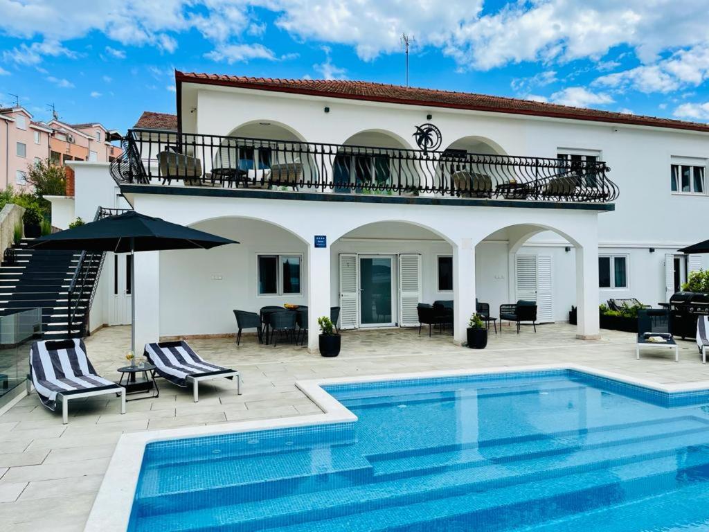 a villa with a swimming pool in front of a house at Villa Gala in Trogir