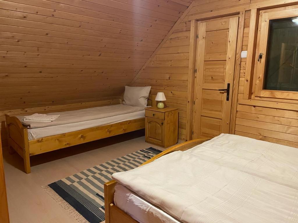 a room with two beds in a wooden cabin at Sikaszoi vizimalom in Sicasău