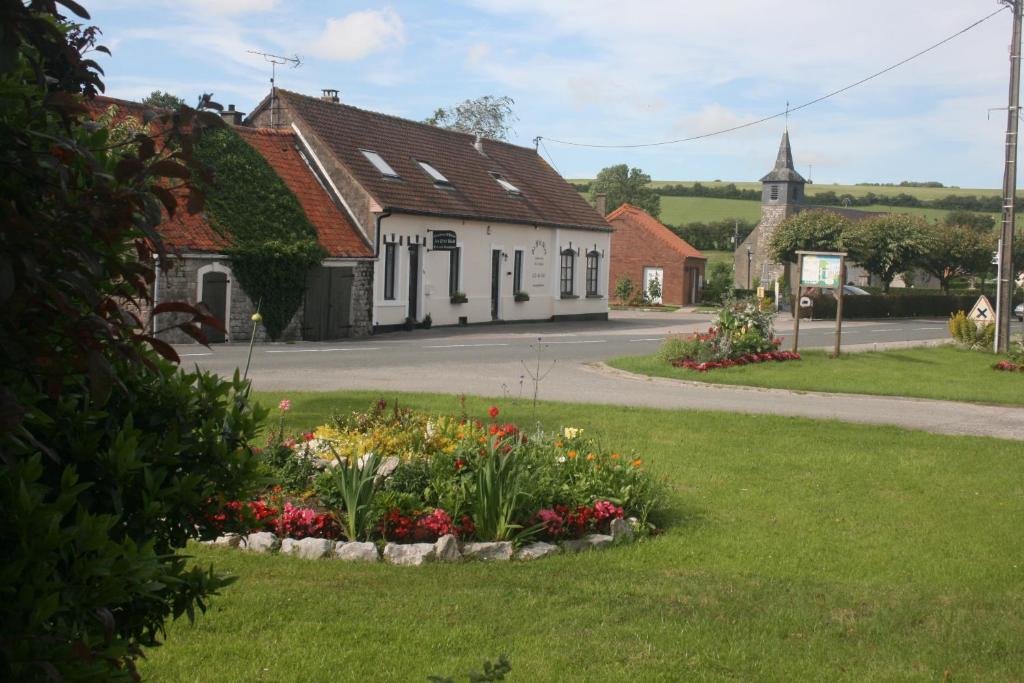 un pueblo con una iglesia y un jardín de flores en Au Petit Bled en Hermelinghen