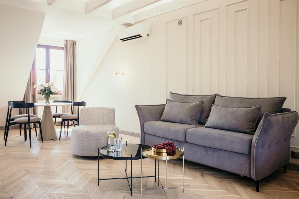 トルンにあるApartamenty Małe Garbaryのソファとテーブルのあるリビングルーム