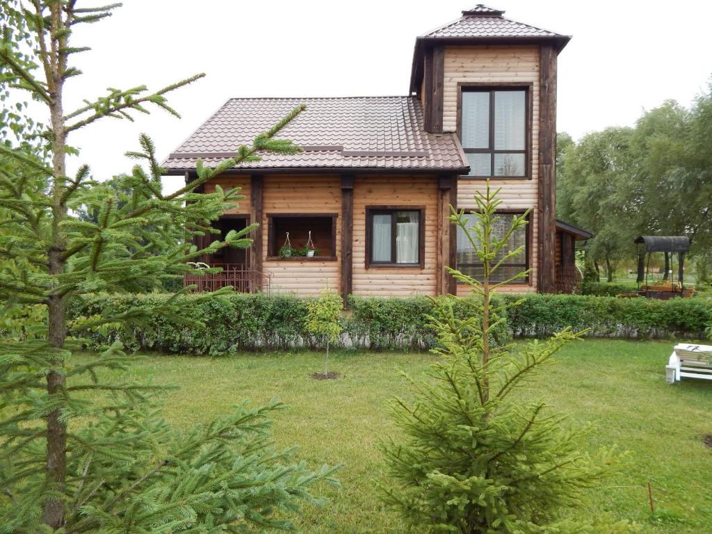 ein Holzhaus in einem Hof mit Bäumen in der Unterkunft Olympic Village in Podgortsy