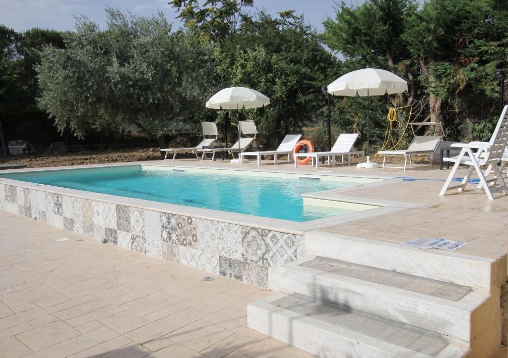 - une piscine avec des chaises longues et des parasols dans l'établissement Abruzzo - Teramo tra Mare e Monti con piscina, à Teramo