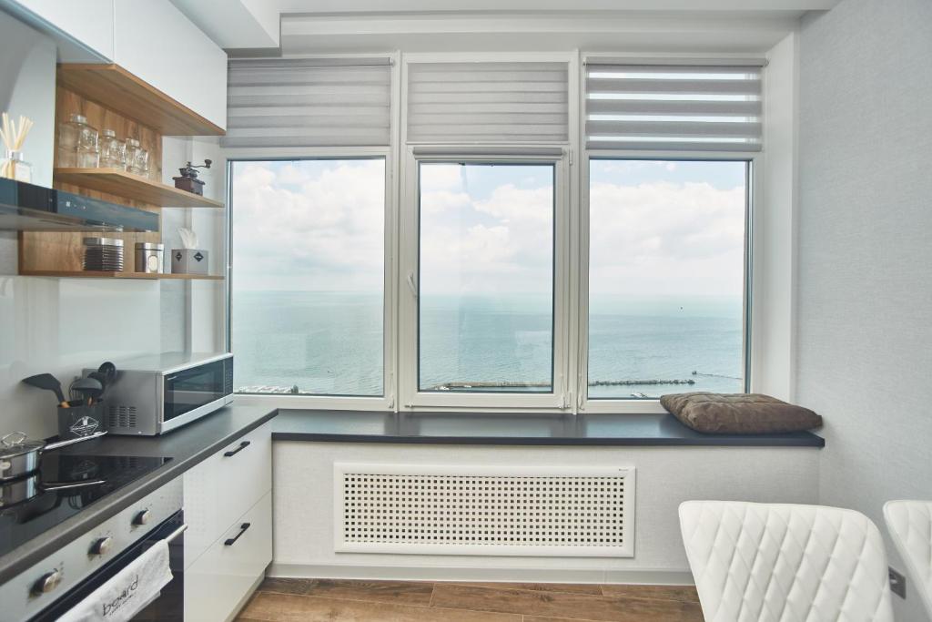 a kitchen with a large window with a view of the ocean at Board apart hotel in Odesa