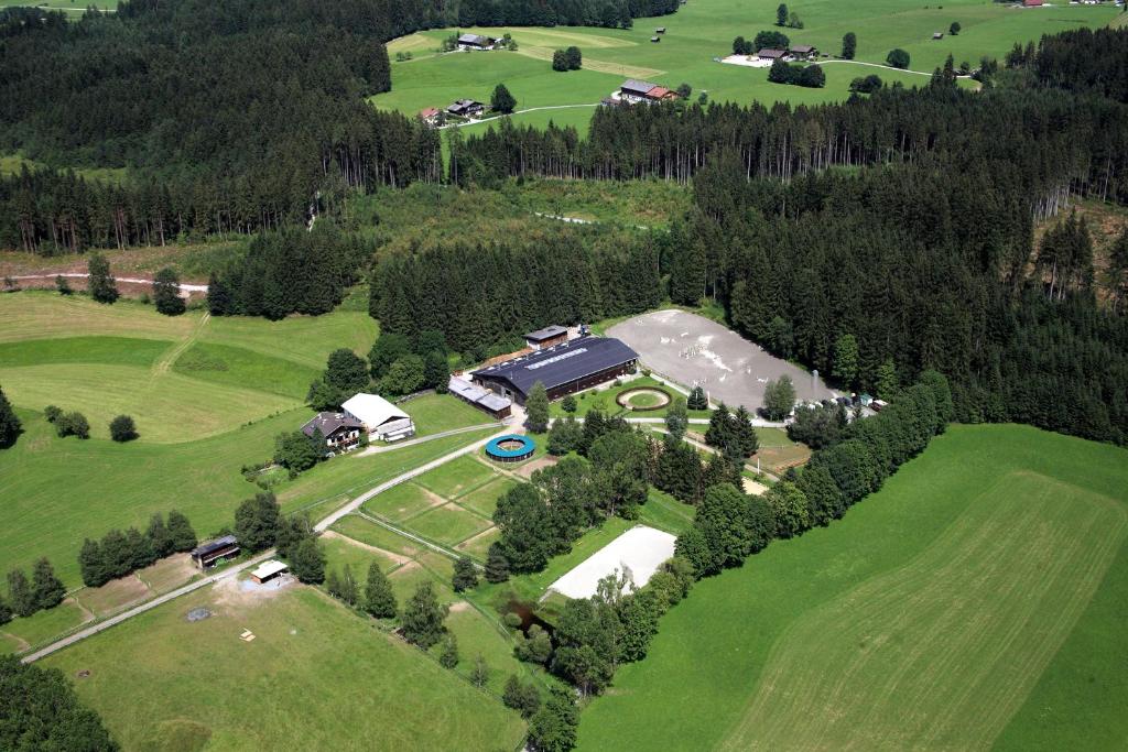 an aerial view of a house in a green field at Ferienwohnung Reitgestüt Waldeck in Saalfelden am Steinernen Meer