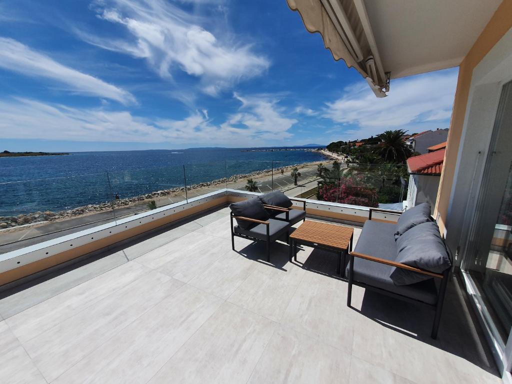 a balcony with two chairs and a table and a view of the ocean at Apartment Danijela No. 2 in Novalja
