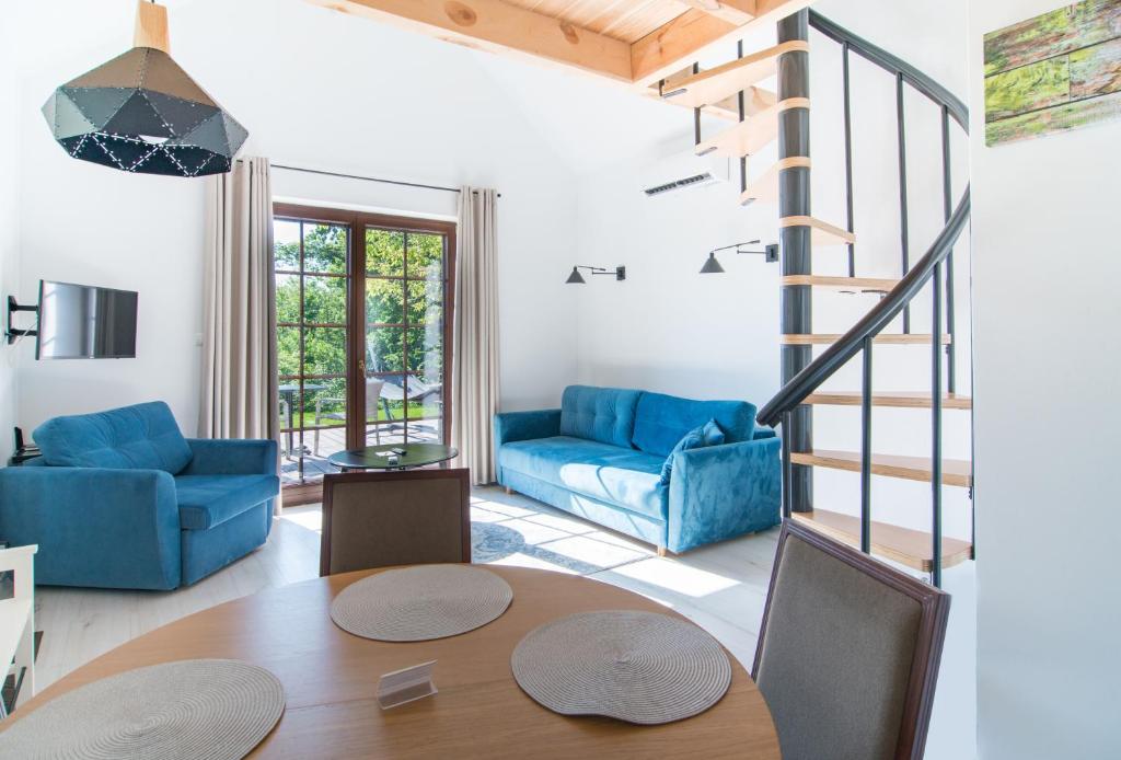 a living room with a table and a blue couch at Kameralny domek Kazimierzówka in Kazimierz Dolny