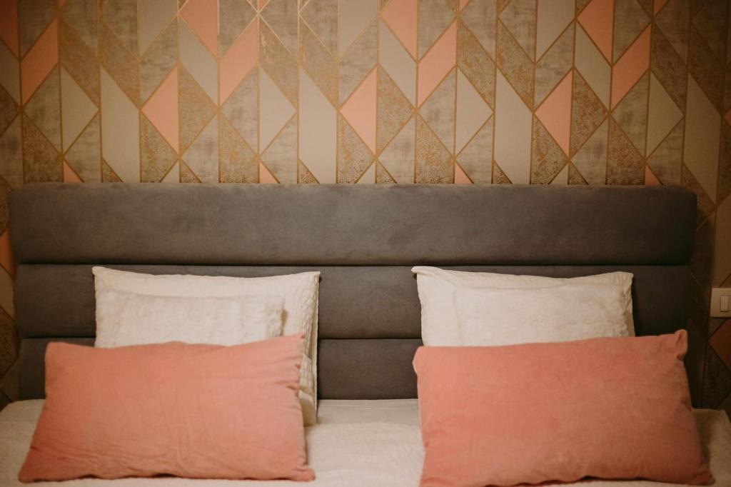 1 cama con 2 almohadas frente a una pared en Apartman Gold en Slavonski Brod