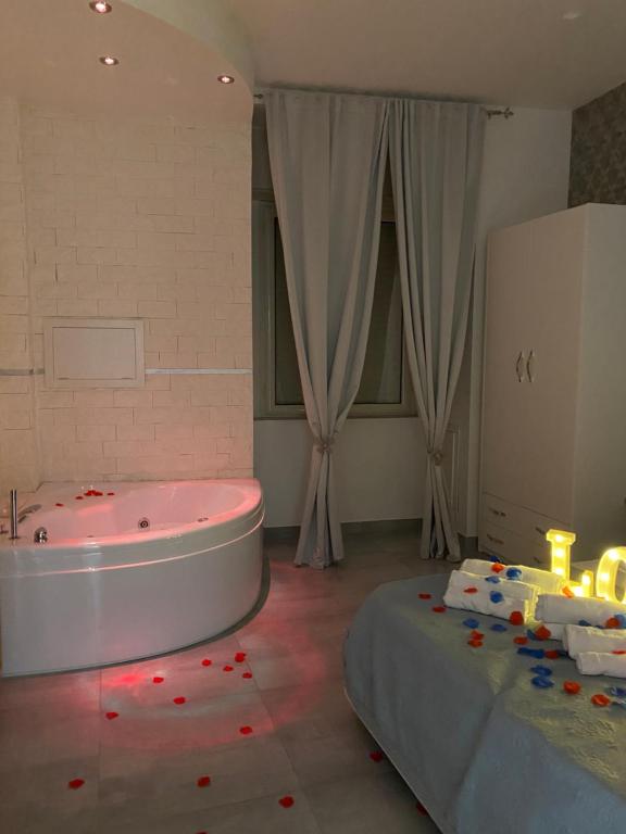 a bathroom with a tub and a bed with candles at Brighter's Room in Naples