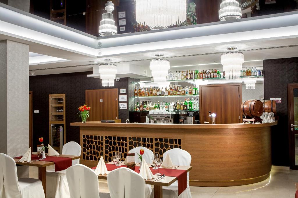 restauracja ze stołami i krzesłami oraz bar w obiekcie Hotel Miodowy Młyn w Opatowie
