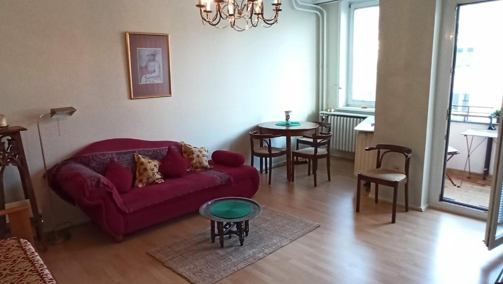 uma sala de estar com um sofá vermelho e uma mesa em Sybel em Berlim