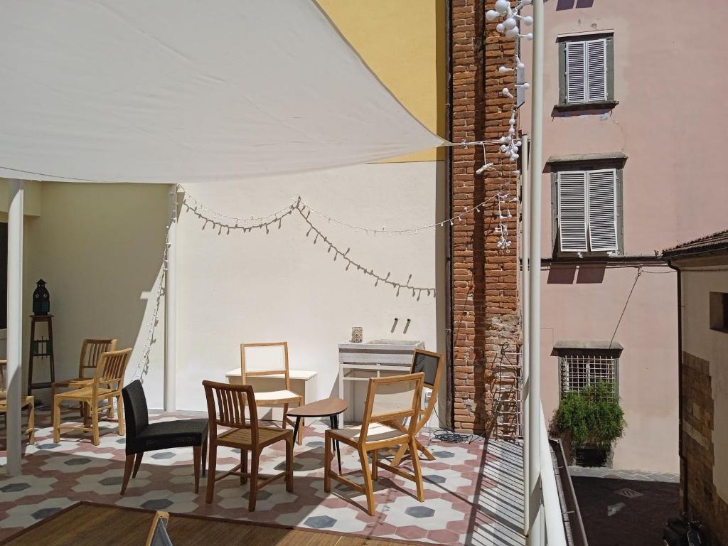 um pátio com cadeiras, uma mesa e um guarda-sol em La Terrazza Del Fotografo em Lucca