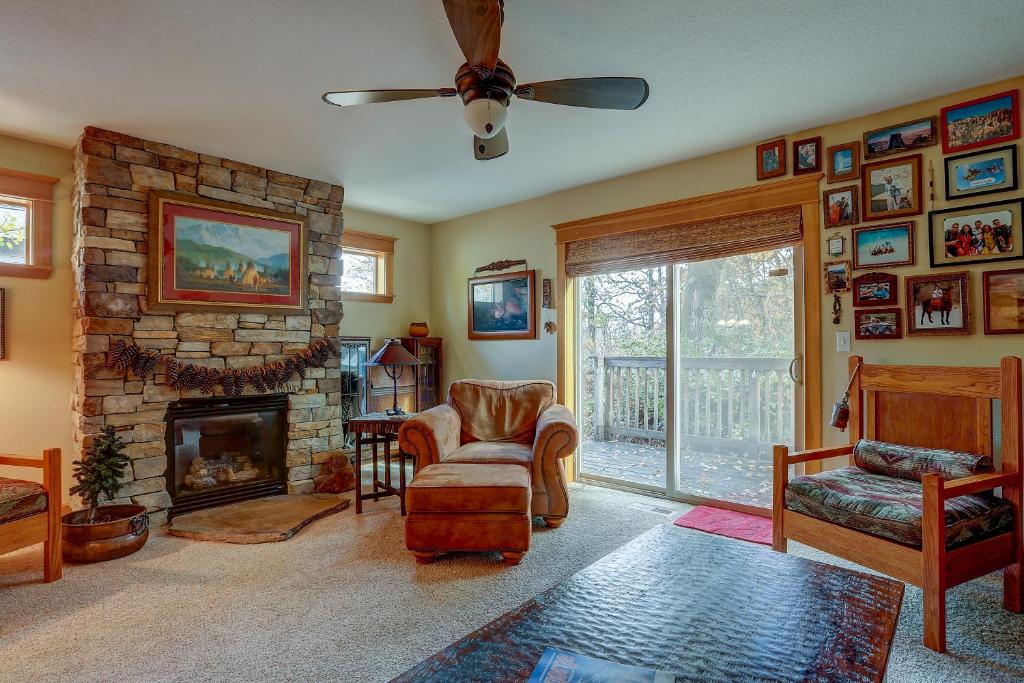 uma sala de estar com uma lareira de pedra e uma ventoinha de tecto em Wanderlust with Rustic Stone Fireplace em Hood River