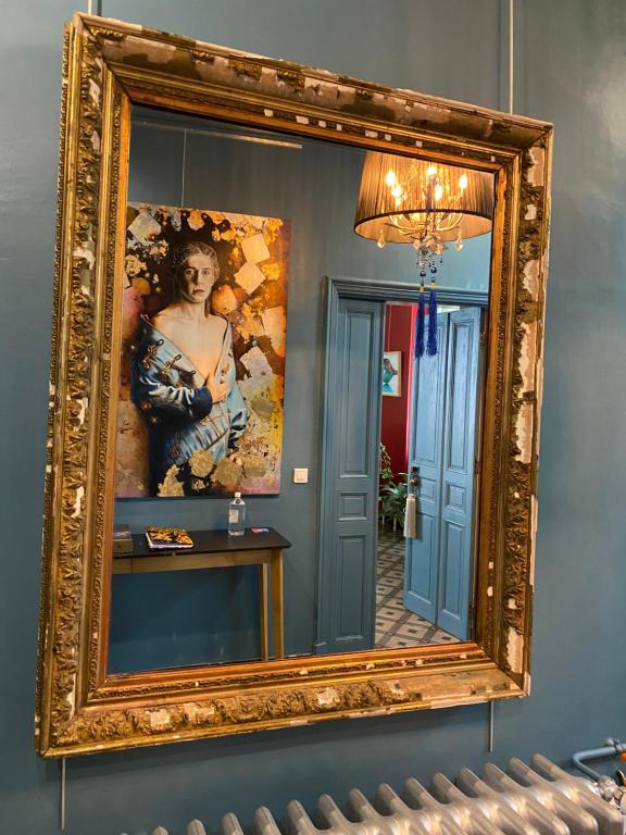 ein Spiegel an einer Wand mit einem Bild einer Frau in der Unterkunft La maison Gerval in Bédoin