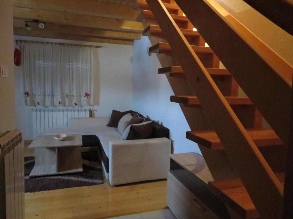 sala de estar con sofá blanco y escaleras en Our House Apartments en Kolašin
