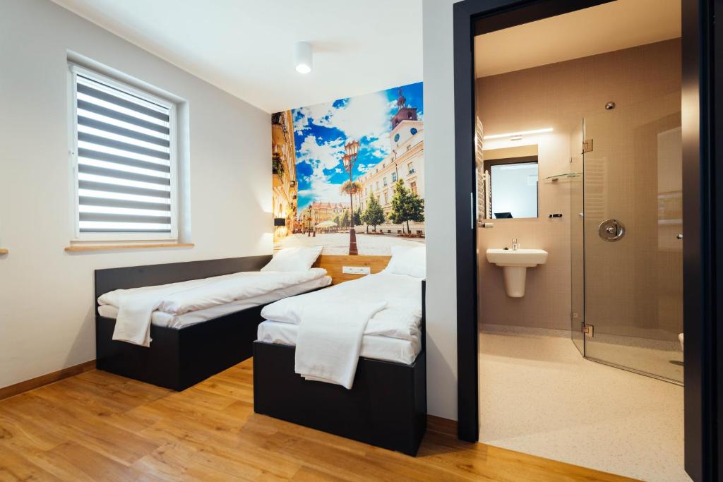 カリシュにあるblue hotelのベッド2台とバスルームが備わる客室です。