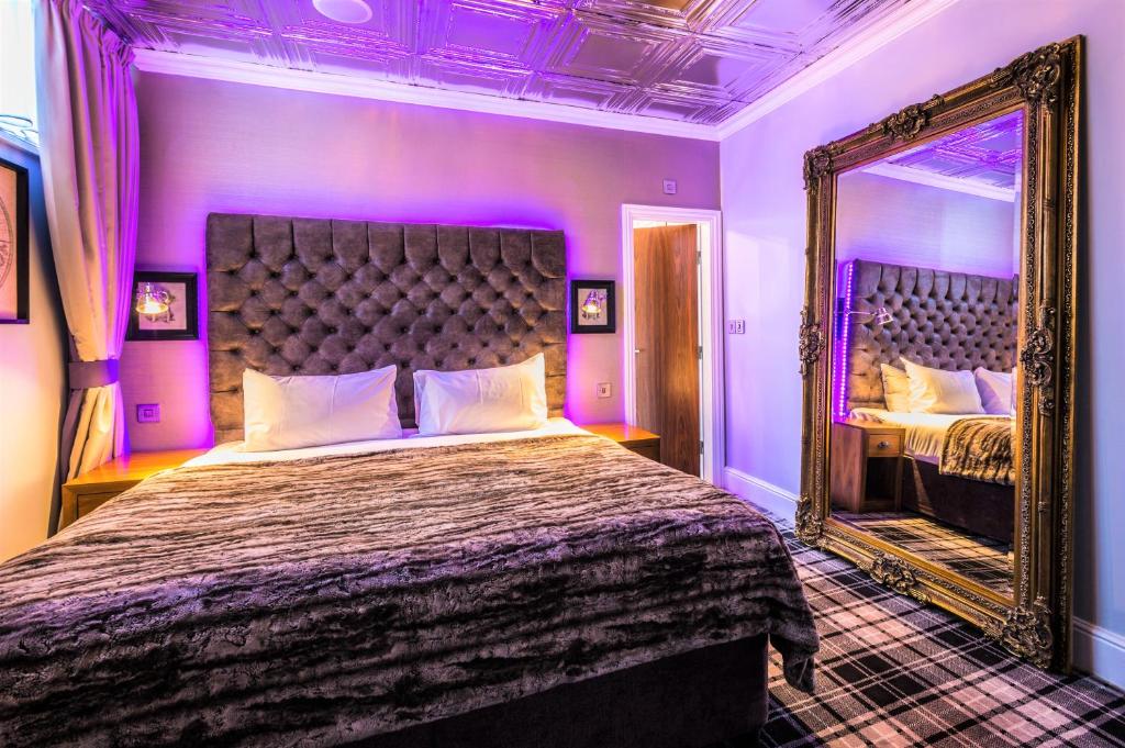 a bedroom with a large bed and a large window at Mercure Nottingham City Centre Hotel in Nottingham