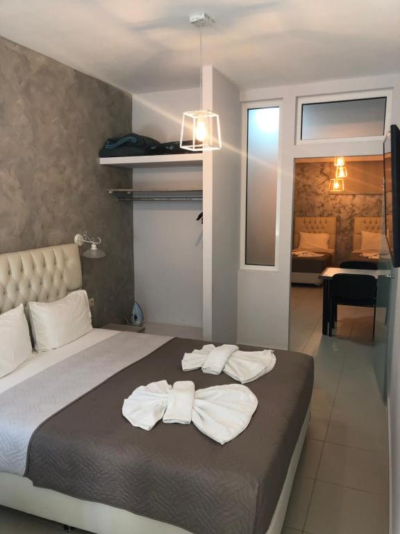 a bedroom with a bed with two towels on it at Labyrinth Hotel in Georgioupolis
