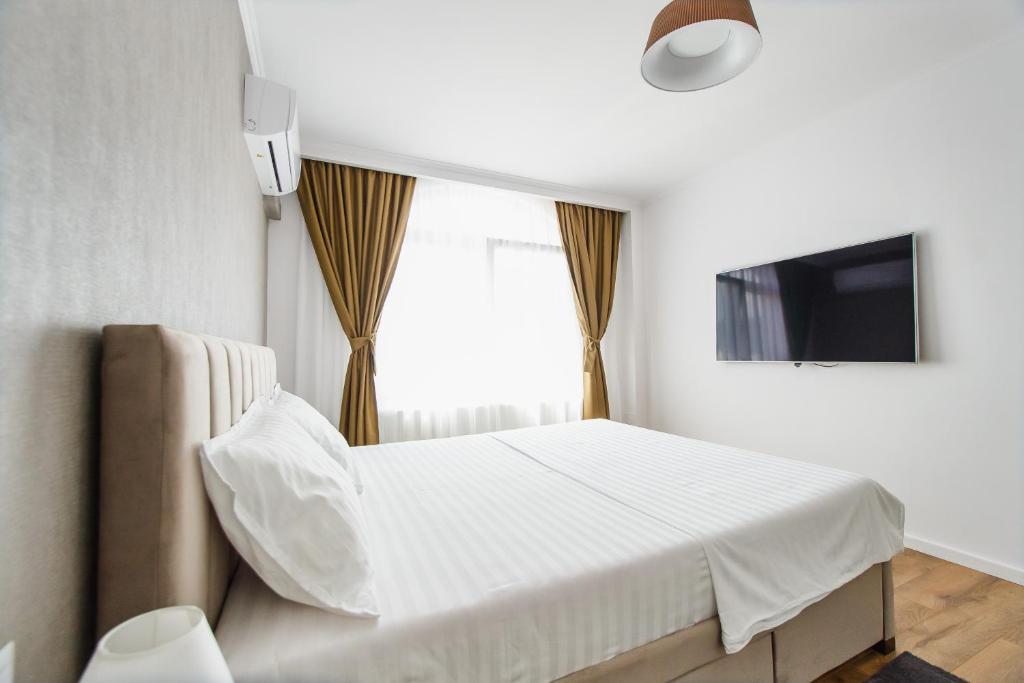 a bedroom with a white bed and a window at Apart Hotel Fresh in Oradea